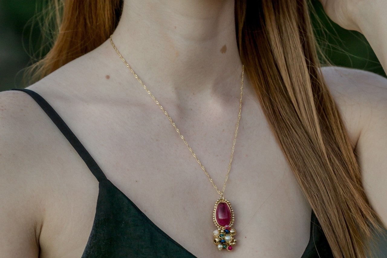 Ruby pendant with enamel and pearl details, plus a gold chain