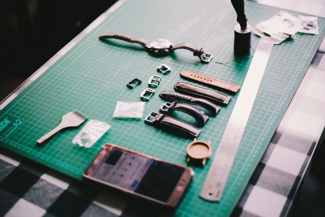 Timepiece next to an assemblage of straps