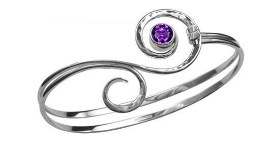 a silver toned bracelet featuring a round but amethyst