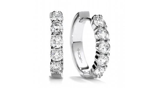 a pair of white gold diamond huggie earrings by Hearts On Fire