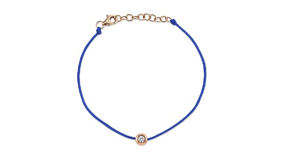 a blue corded bracelet with bezel set round cut diamond