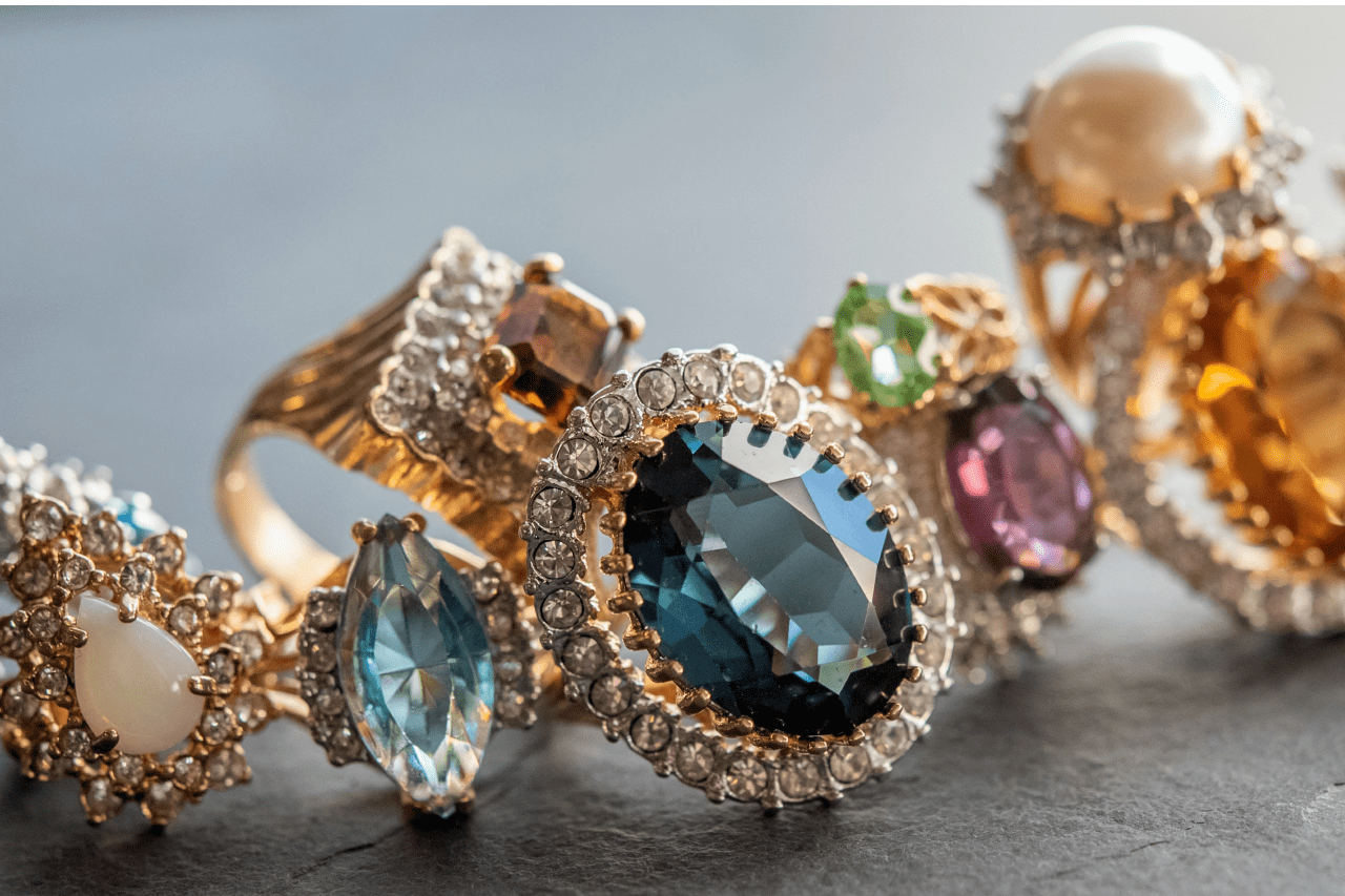 a cluster of elaborate gemstone jewelry on a gray surface