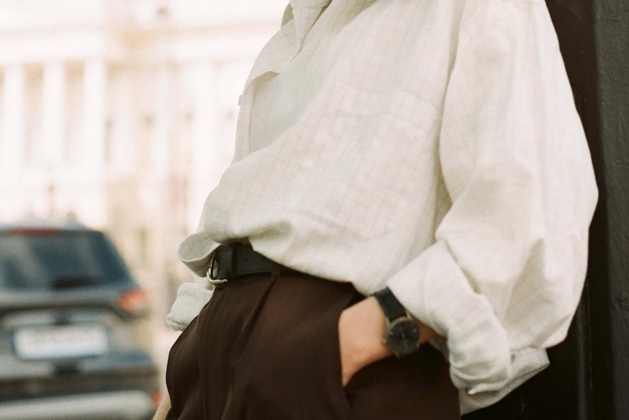 A person wearing a black leather watch