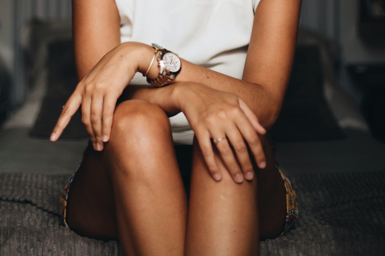 lady with her hands on her lap wearing a luxury timepiece