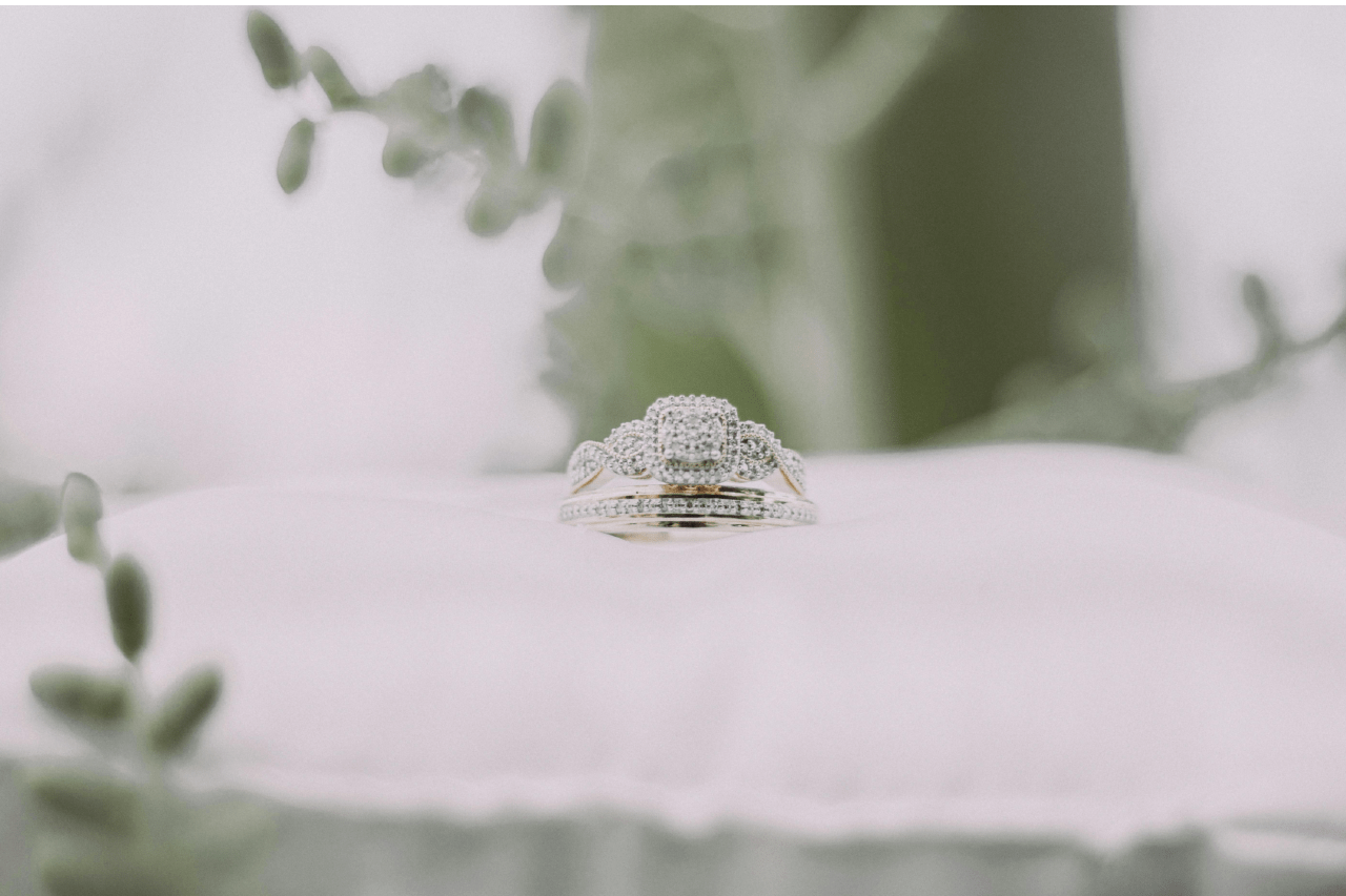 A stunning white gold engagement ring resting on a white pillow.