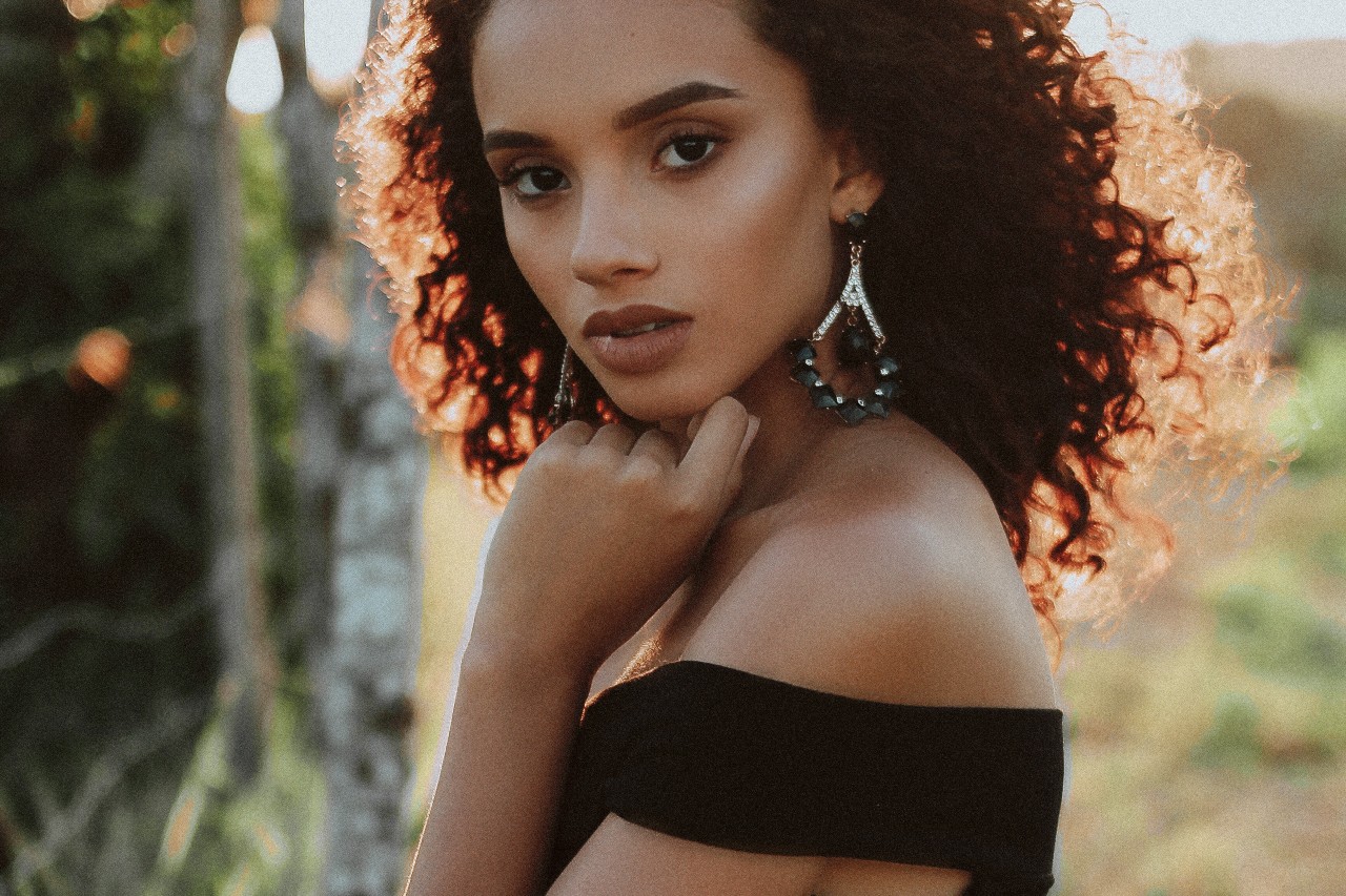 lady wearing large earrings with gemstones