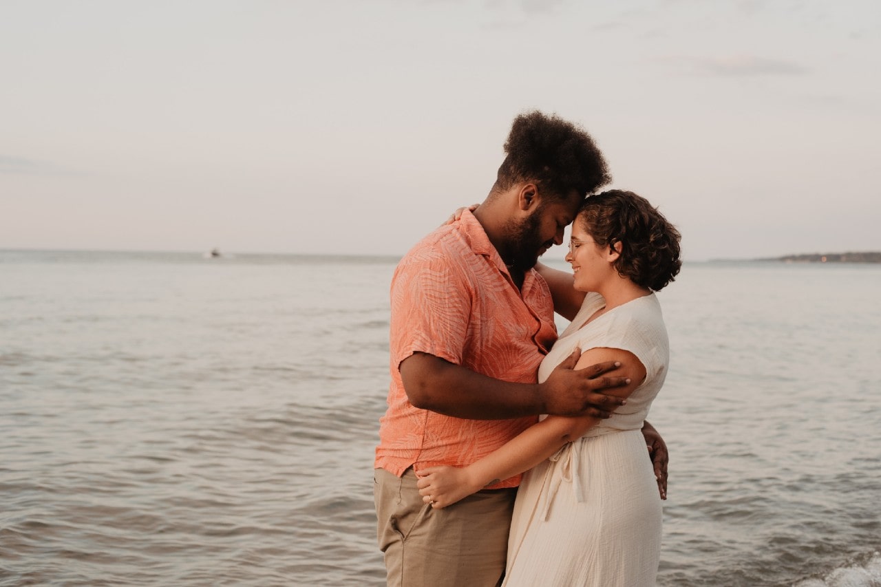 A couple shares an intimate moment at a beach.