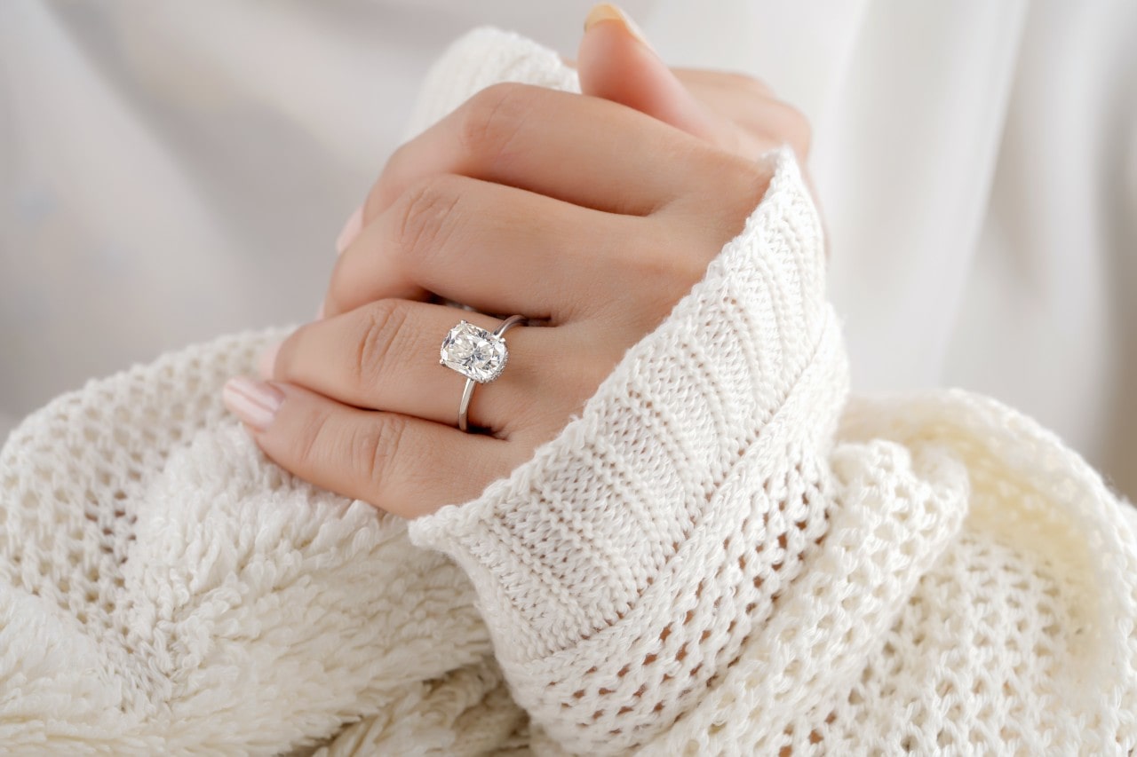 a lady’s hand wearing a simple cushion cut engagement ring